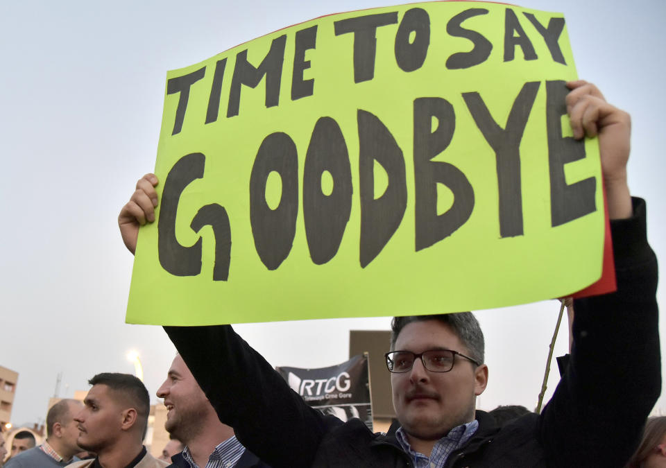 In this Saturday, March 23, 2019 file photo, a man holds a banner during a protest against President Milo Djukanovic in Montenegro's capital Podgorica. Montenegro's president says the upcoming parliamentary vote is crucial in the defense of the small Balkan country's independence in the face of renewed attempts from Serbia and Russia to install their nationalist and anti-Western allies to power. (AP Photo/Risto Bozovic, File)