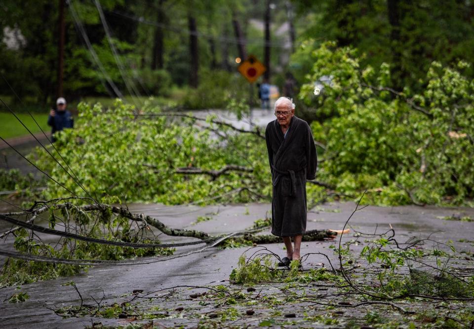 Bill Johnson looks at the downed trees and power lines from the storm the night before on Northampton Drive in Jackson, Miss., on Wednesday, April 10, 2024. "Sounded like a freight train going over," Johnson said.