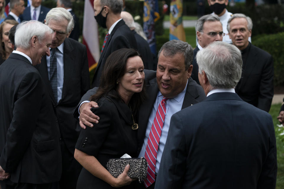 In this Saturday, Sept. 26, 2020, photo former New Jersey Gov. Chris Christie, front second from right, speaks with others after President Donald Trump announces Judge Amy Coney Barrett as his nominee to the Supreme Court in the Rose Garden of the White House, in Washington. Notre Dame President Father John Jenkins stands at back right. (AP Photo/Alex Brandon)