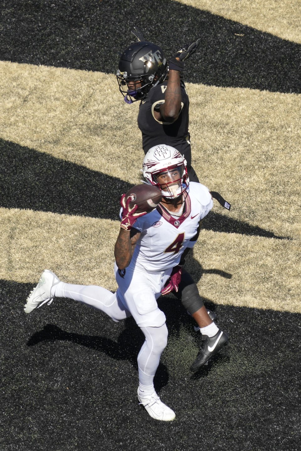 Florida State wide receiver Keon Coleman (4) catches a touchdown pass against Wake Forest defensive back Caelen Carson (1) during the first half of an NCAA college football game in Winston-Salem, N.C., Saturday, Oct. 28, 2023. (AP Photo/Chuck Burton)