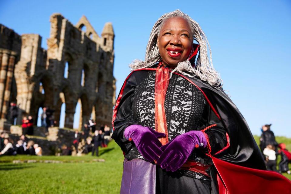 A participant at the vampire gathering in cape and fangs