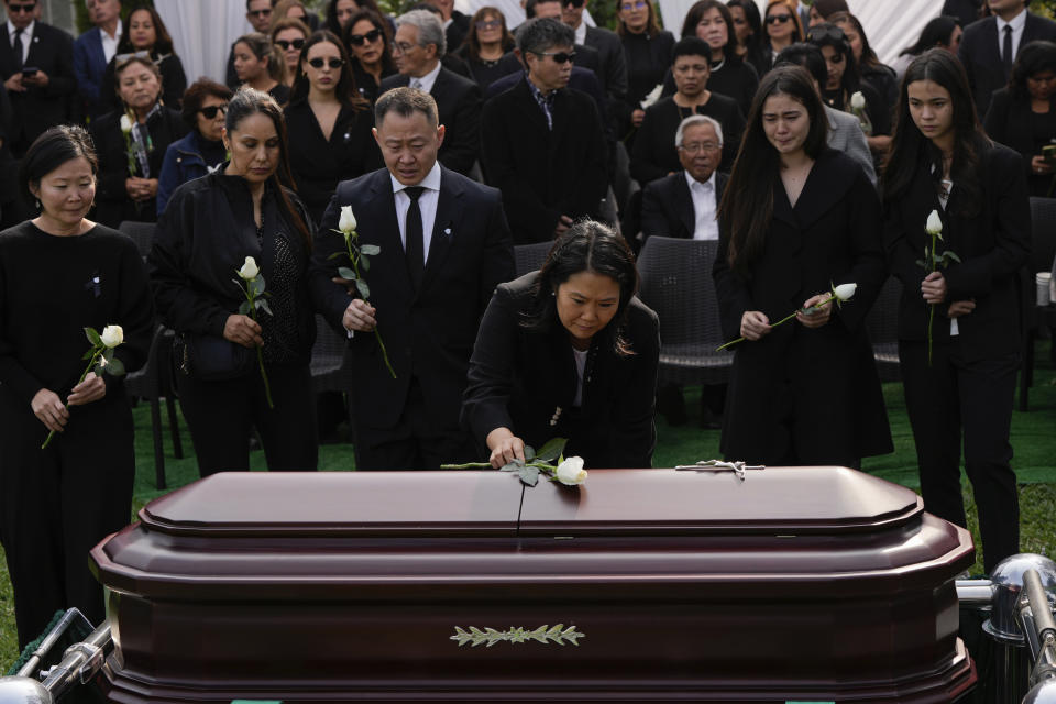 Keiko Fujimori places a flower over the coffin of her father, former President Alberto Fujimori, in Lima, Peru, Saturday, Sept. 14, 2024. (AP Photo/Guadalupe Pardo)