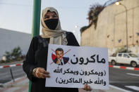 An Arab Israeli Muslim demonstrator, clad in mask due to the COVID-19 coronavirus pandemic, holds up a sign during a rally protesting against the comments of French President Emmanuel Macron over Prophet Mohammed cartoons, in the Arab town of Umm-Al Fahem in Northen Israel on October 25, 2020. (Photo by Ahmad GHARABLI / AFP) (Photo by AHMAD GHARABLI/AFP via Getty Images)