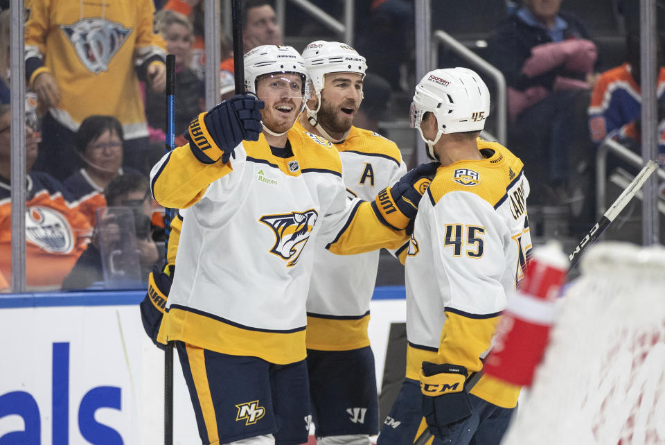 Nashville Predators' Gustav Nyquist (14), Ryan O'Reilly (90) and Alexandre Carrier (45) celebrate a goal against the Edmonton Oilers during the third period of an NHL game in Edmonton, Alberta, Saturday, Nov. 4, 2023. (Jason Franson/The Canadian Press via AP)