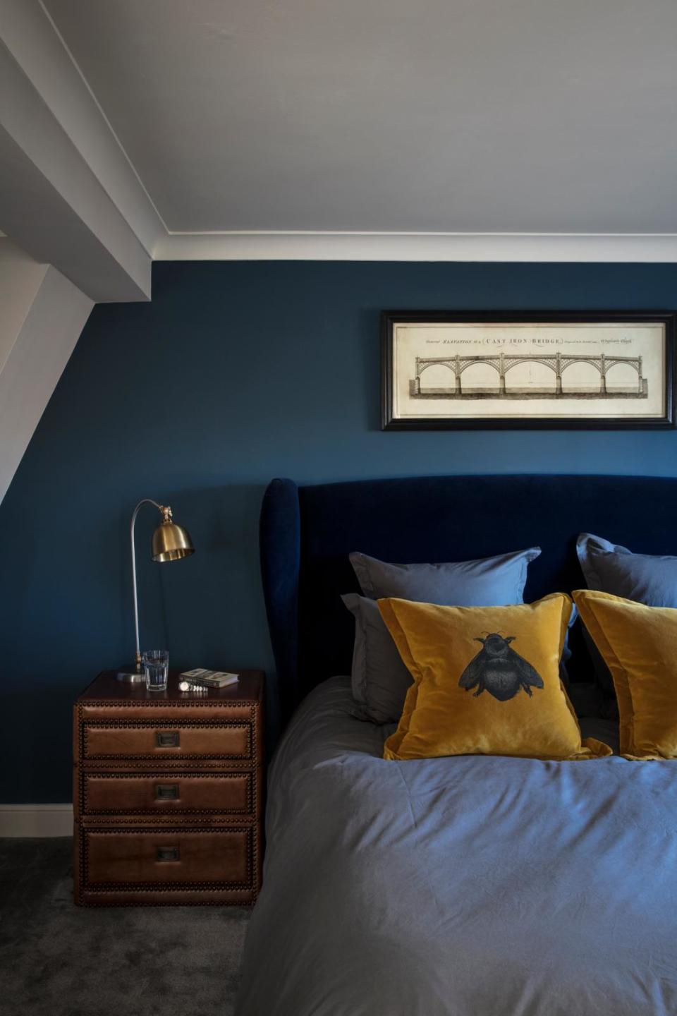 Deep blue loft bedroom with yellow throw pilows