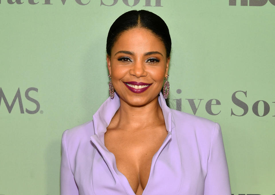 Sanaa wears a lilac collared blazer dress with a plunging neckline