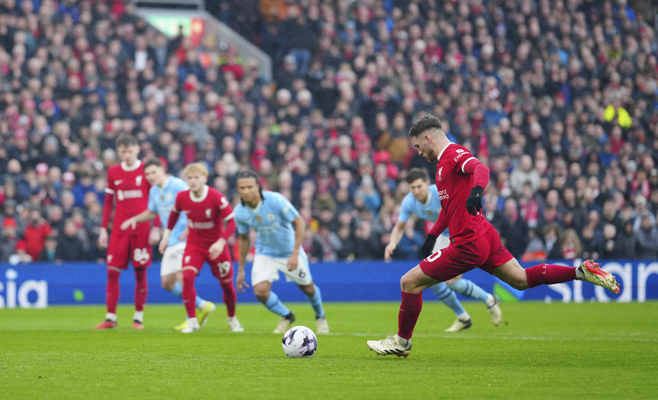 Liverpool's Alexis Mac Allister scores a penalty, his side's first goal during the English Premier League soccer match between Liverpool and Manchester City, at Anfield stadium in Liverpool, England, Sunday, March 10, 2024. (AP Photo/Jon Super)