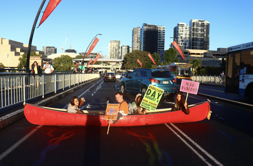 The four protestors in the canoe on Thursday morning on Victoria Bridge, Brisbane.