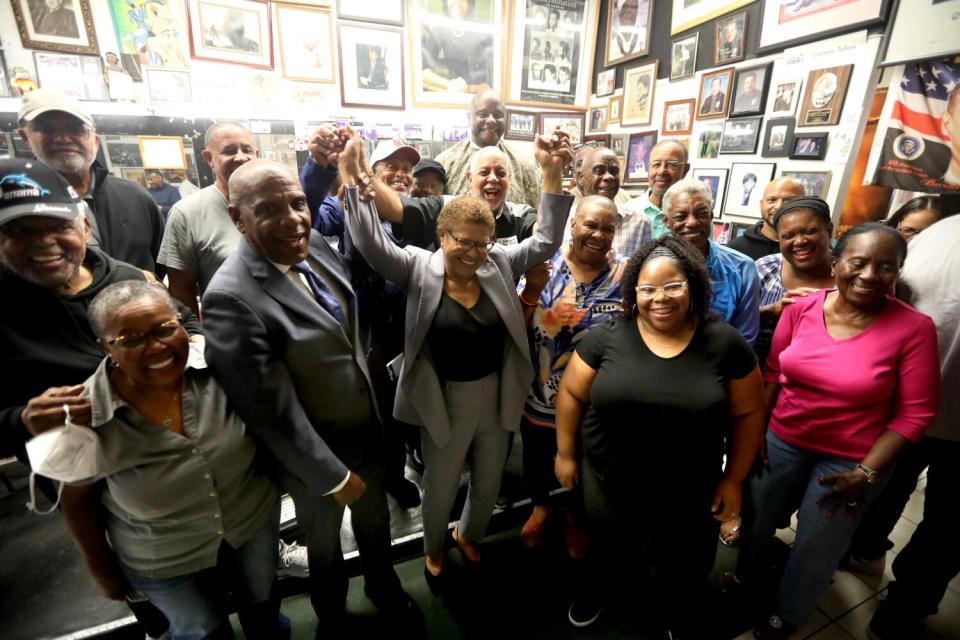 Rep. Karen Bass joins a crowd of voters to hear their concerns at Tolliver's Barber Shop.