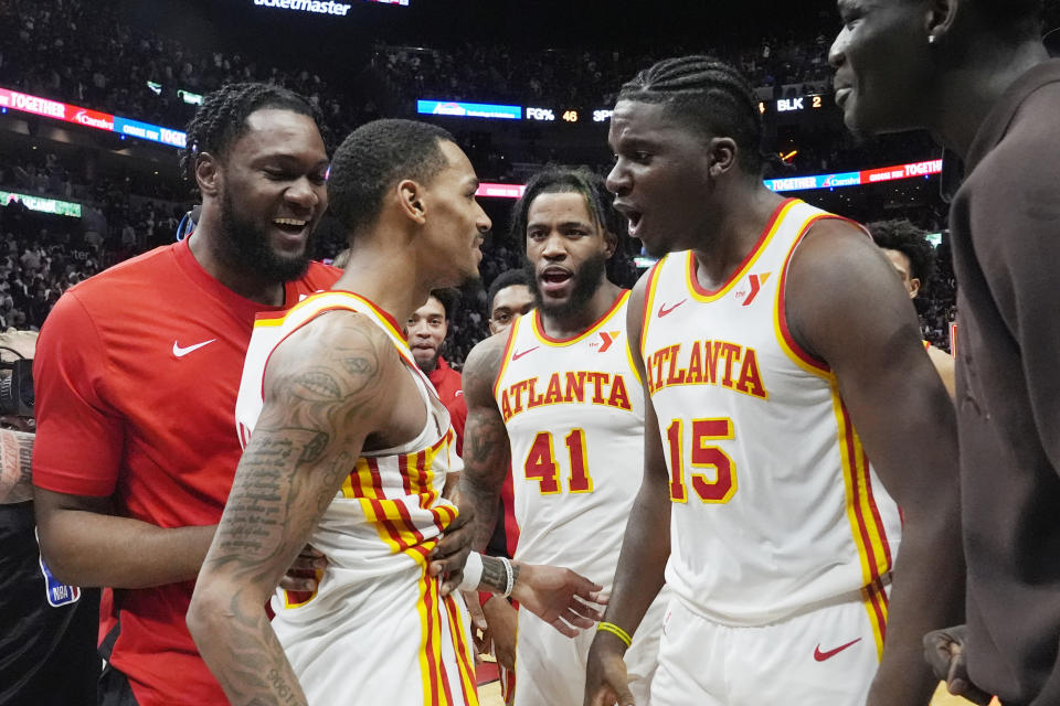 Atlanta Hawks players congratulate guard Dejounte Murray, left, after he scored the game winning basket during the second half of an NBA basketball game against the Miami Heat, Friday, Jan. 19, 2024, in Miami. The Hawks defeated the Heat 109-108. (AP Photo/Marta Lavandier)