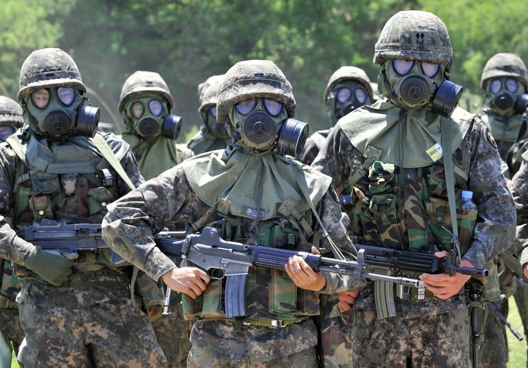 South Korean soldiers wearing gas masks take part in a training exercise in in Yeoncheon, May 16, 2013. Military service is taken extremely seriously South Korea, which remains technically at war with North Korea because their 1950-53 conflict ended with a ceasefire rather than a peace treaty