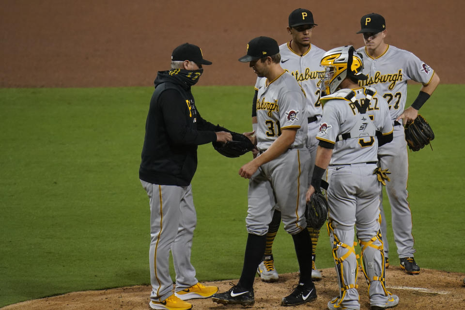 Pittsburgh Pirates manager Derek Shelton, left, takes the ball from starting pitcher Tyler Anderson, second from left, during the seventh inning of a baseball game against the San Diego Padres, Monday, May 3, 2021, in San Diego. (AP Photo/Gregory Bull)