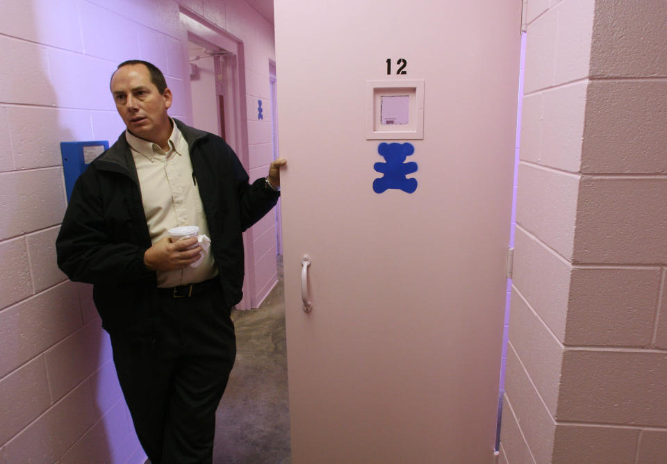 Dallas County sheriff Mike Rackley holds a pink cell door painted with a stencil of a teddy bear while talking about his jail's new color scheme, Thursday, November 2, 2006, in Buffalo, Mo. Rackley decided to turn things pink after vandalism and a small riot by inmates forced him to make repairs at the facility. (Photo by Mark Schiefelbein/WireImage)
