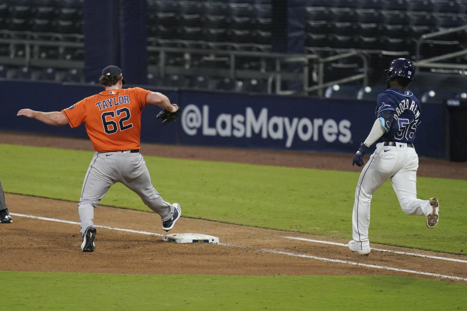 Houston Astros pitcher Blake Taylor tags first base ahead of Tampa Bay Rays Randy Arozarena during the seventh inning in Game 6 of a baseball American League Championship Series, Friday, Oct. 16, 2020, in San Diego. (AP Photo/Gregory Bull)