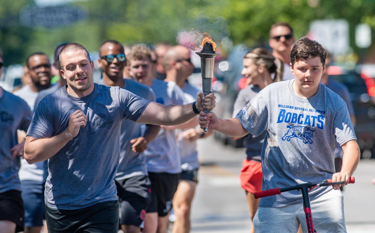 Matt Hayes, Hilliard police officer, and Special Olympian Aiden McCue participate in the Special Olympics Law Enforcement Torch Run on June 21 in Hilliard.