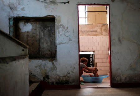 A woman bathes a baby in a communal bathroom at the abandoned Prestes Maia textile factory occupied by a homeless movement in downtown Sao Paulo, Brazil, May 10, 2018. REUTERS/Nacho Doce