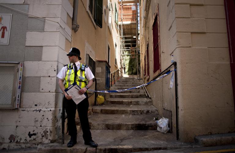 A policeman stands guard in Boschetti Street in Gibraltar where four Britons were found dead on March 30, 2015