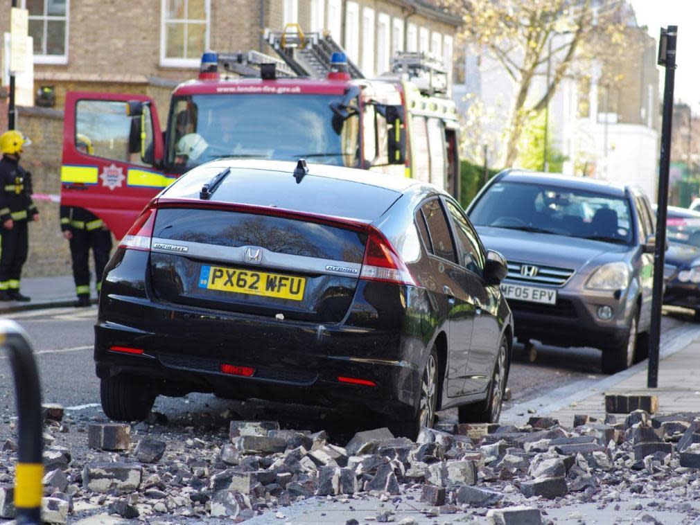 A mother and her baby had a narrow escape when rubble fell from the top of a tower block and into the road in Hackney, east London: Screengrab/Twitter, @LundunFeeldz