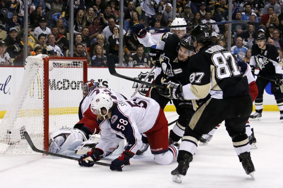 Pittsburgh Penguins' Chris Kunitz (14) puts the puck behind Columbus Blue Jackets goalie Sergei Bobrovsky (72) and David Savard (58) for a goal in the second period of Game 5 of a first-round NHL playoff hockey series in Pittsburgh Saturday, April 26, 2014. (AP Photo/Gene J. Puskar)