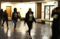 In this Nov. 19, 2019, photo, asylum seekers from Central America and Cuba follow an Immigration and Customs Enforcement guard into the Richard C. White Federal Building in El Paso, Texas. They are some of the thousands of migrants forced to wait in Mexico pending their applications for asylum, and are only allowed into the U.S. for court hearings, in ICE custody. (AP Photo/Cedar Attanasio)