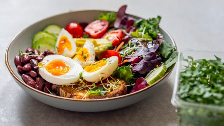 A salad with red leaf lettuce, hard-boiled eggs, and tomatoes