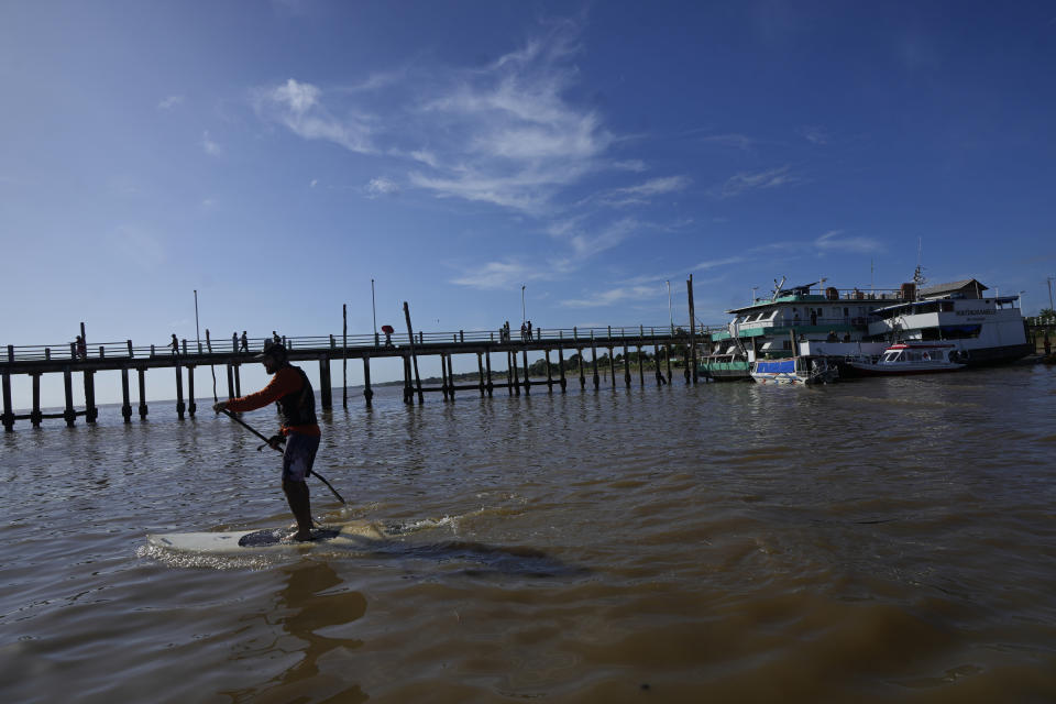 A surfer paddles out to ride the tidal bore wave known as "Pororoca," during the Amazon Surf Festival held in the Canal do Perigoso, or "Dangerous Channel," at the mouth of the Amazon River near Chaves, Marajo Island archipelago, Para state, Brazil, Monday, June 5, 2023. The Pororoca, a word from an Amazonian Indigenous dialect that means "destroyer" or "great blast," happens twice a day when the incoming ocean tide reverses the river flow for a time. (AP Photo/Eraldo Peres)