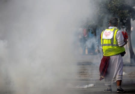 A protester wearing a yellow vest walks among tear gas as protesters clash with French riot police during a demonstration on Act 44 (the 44th consecutive national protest on Saturday) of the yellow vests movement in Nantes