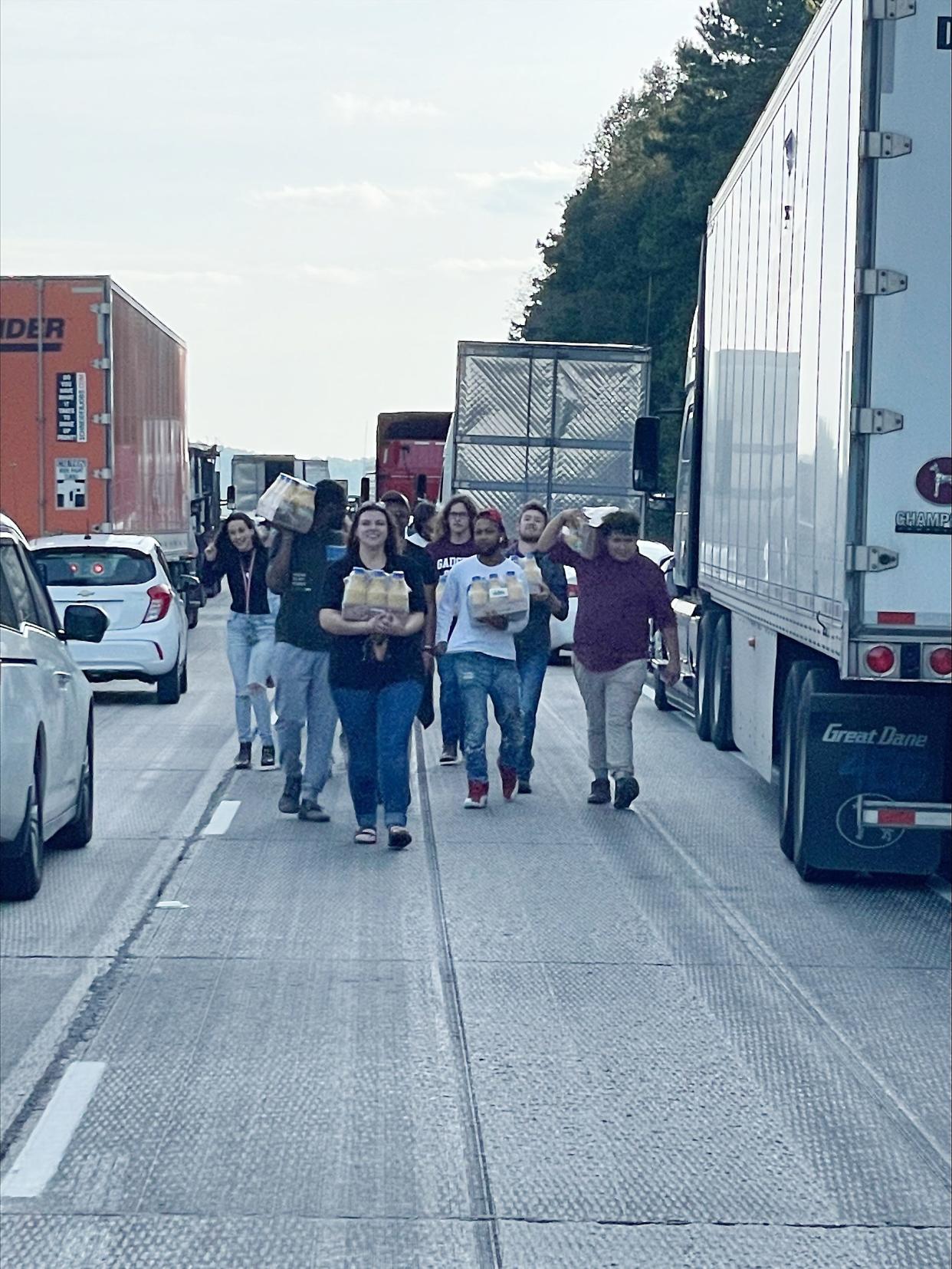 Members of the Gadsden State Community College Show Band are pictured walking down Interstate 59 on Oct. 14 after being snarled in a traffic jam. Some of those students in the GSCC group, which was headed to a clinic and concert in Birmingham, helped distribute orange juice to others caught in the jam.