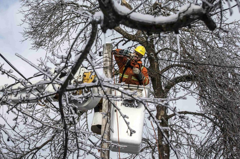 A Toronto Hydro employee works to restore power in the Scarborough suburb following an ice storm in Toronto, December 27, 2013. Over 30,000 residents were left without power in Toronto Friday since the storm hit on December 22, local media reported. REUTERS/Mark Blinch (CANADA - Tags: ENVIRONMENT ENERGY)