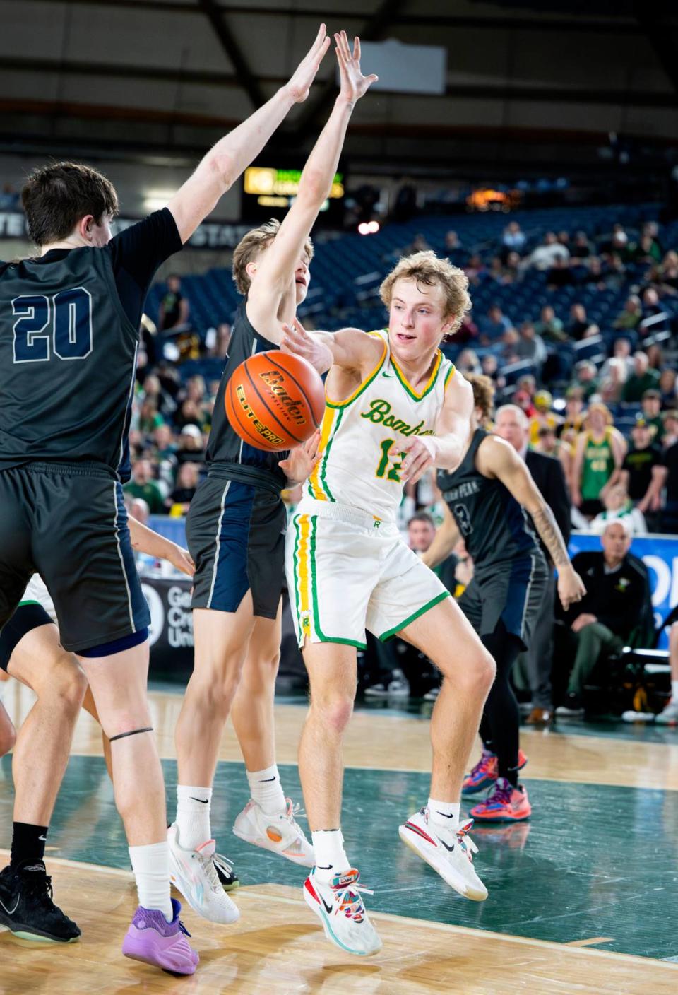 Richland’s Joshua Woodard (12) dishes the ball during the semifinals game of the Class 4A state tournament at the Tacoma Dome, on Friday, March 1, 2024, in Tacoma, Wash.