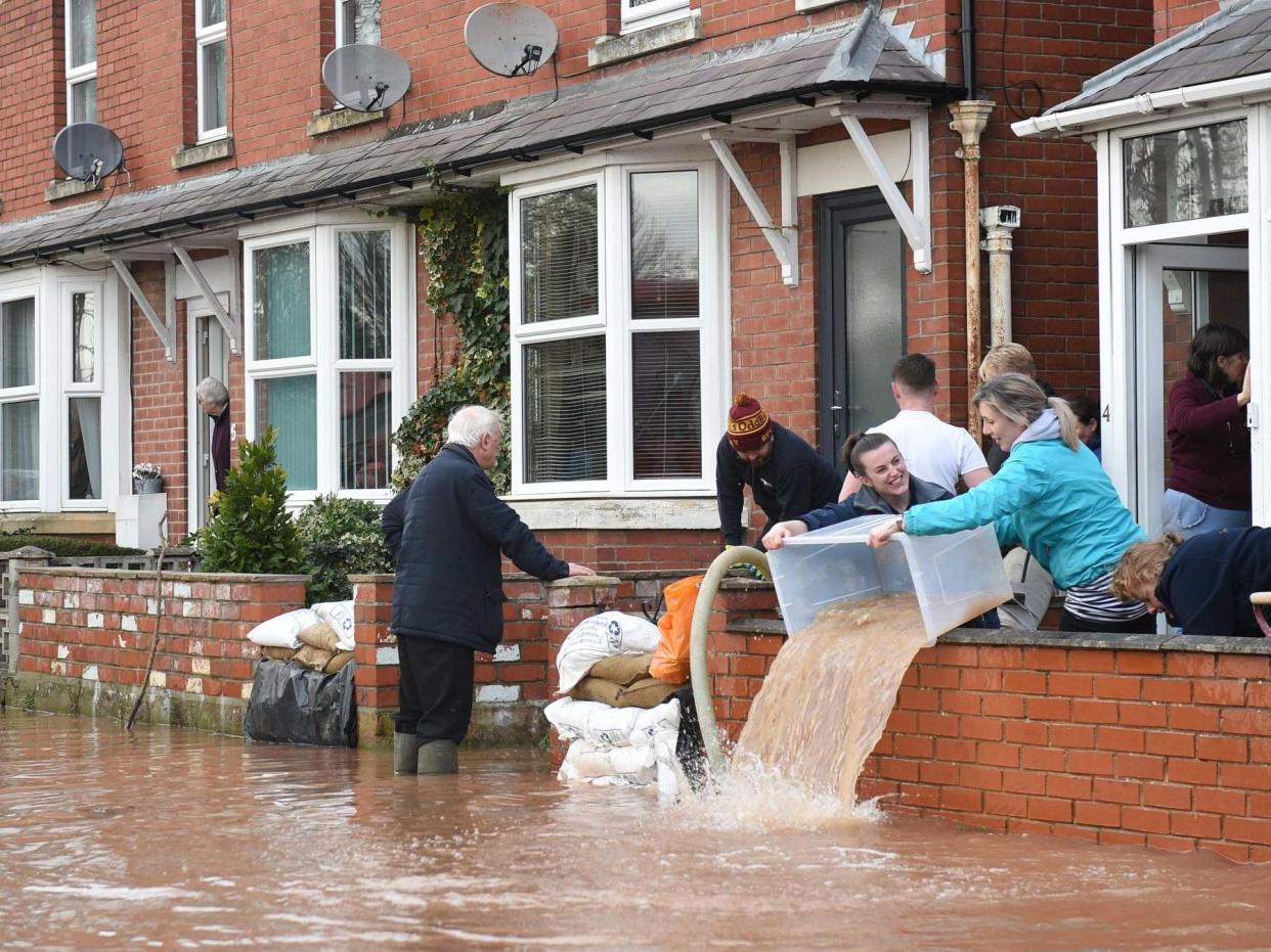 People bail water out of flooded homes after the River Wye burst its banks in Ross-on-Wye, western England: AFP