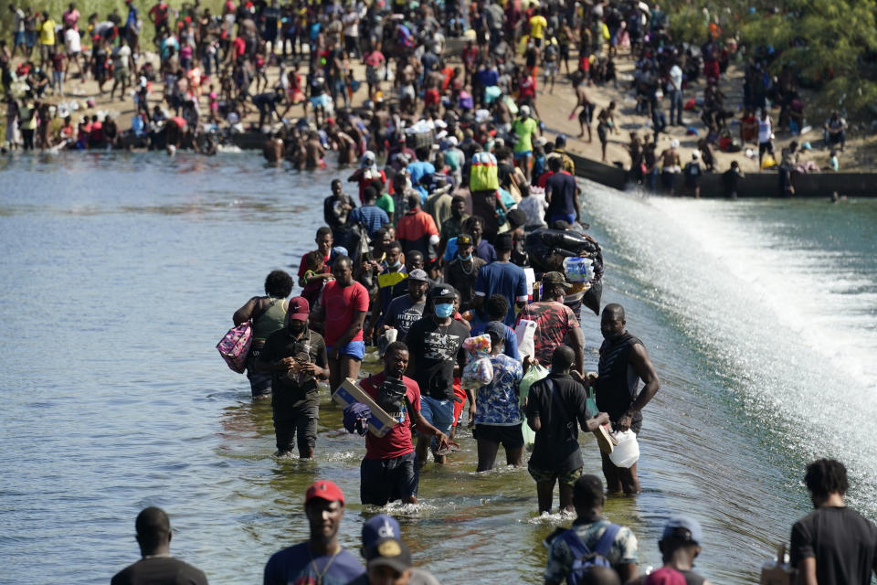 Haitian migrants use a dam to cross to and from the United States from Mexico, Friday, Sept. 17, 2021, in Del Rio, Texas. Thousands of Haitian migrants have assembled under and around a bridge in Del Rio presenting the Biden administration with a fresh and immediate challenge as it tries to manage large numbers of asylum-seekers who have been reaching U.S. soil. (AP Photo/Eric Gay)