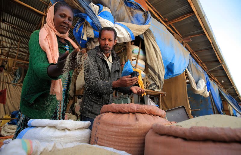 Legese Yadasa and his wife Damitu Ebisa sample Teff for food in a grain market at the Merkato neighbourhood of Addis Ababa