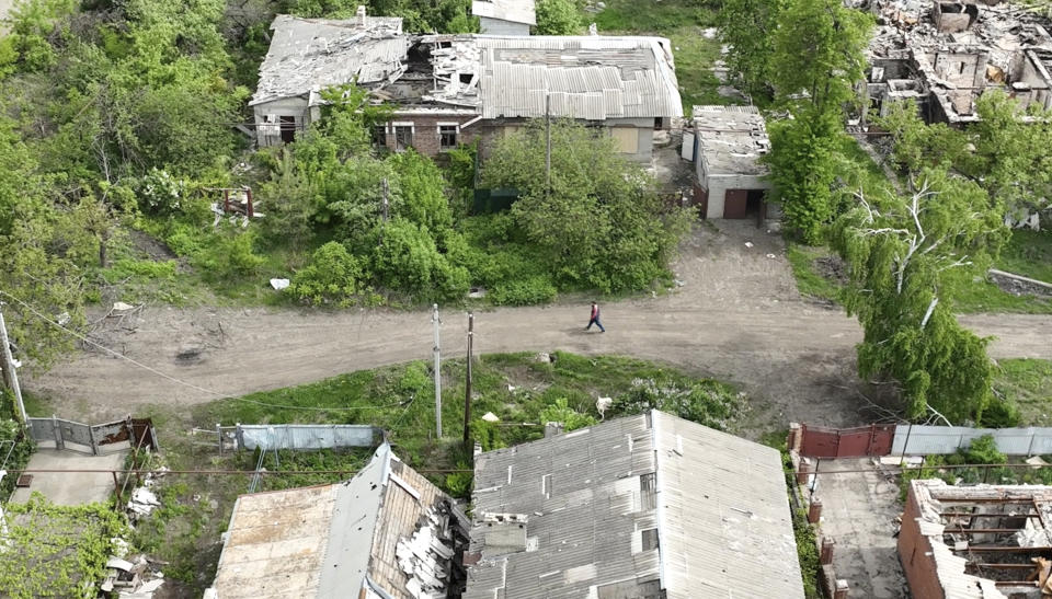 This photo taken from a drone video provided by Ukraine Patrol Police, shows a man walking through devastation in Chasiv Yar, an eastern Ukrainian city Russia is assaulting, Ukraine, Monday, April 29, 2024. The footage shows the community of Chasiv Yar - which is set amid green fields and woodland - reduced to a skeletal ghost town with few residents left. The apocalyptic scene is reminiscent of the cities of Bakhmut and Avdiivka, which Ukraine yielded after months of bombardment and huge losses for the Kremlin’s forces. (Ukraine Patrol Police via AP)