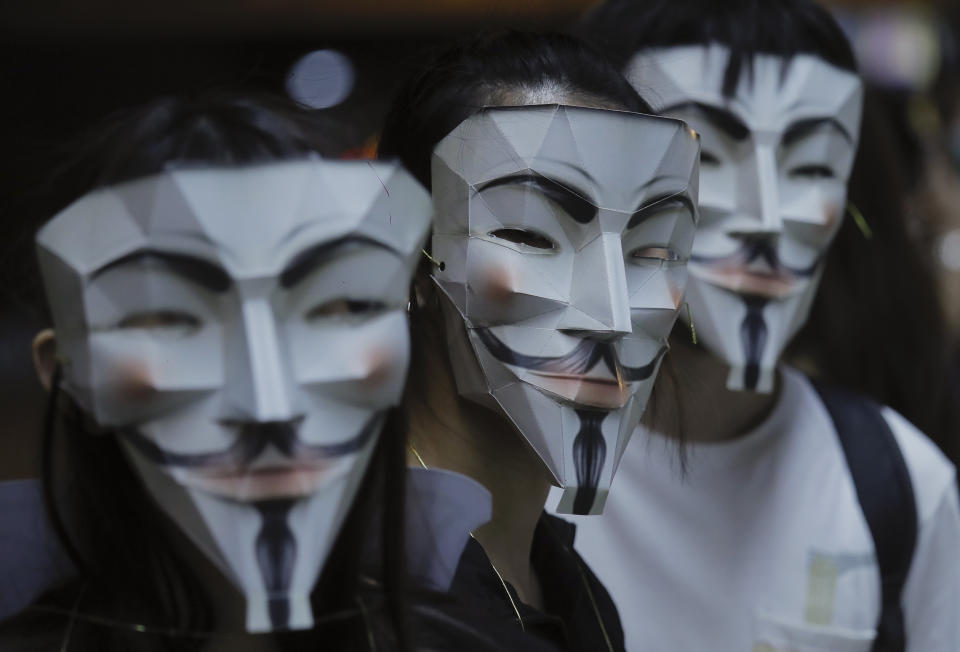 Protesters wear masks in Hong Kong, Friday, Oct. 18, 2019. Hong Kong pro-democracy protesters are donning cartoon/superheroes masks as they formed a human chain across the semiautonomous Chinese city, in defiance of a government ban on face coverings. (AP Photo/Kin Cheung)