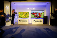 Show attendees photograph Panasonic's new televisions during a news conference at the International Consumer Electronics Show.