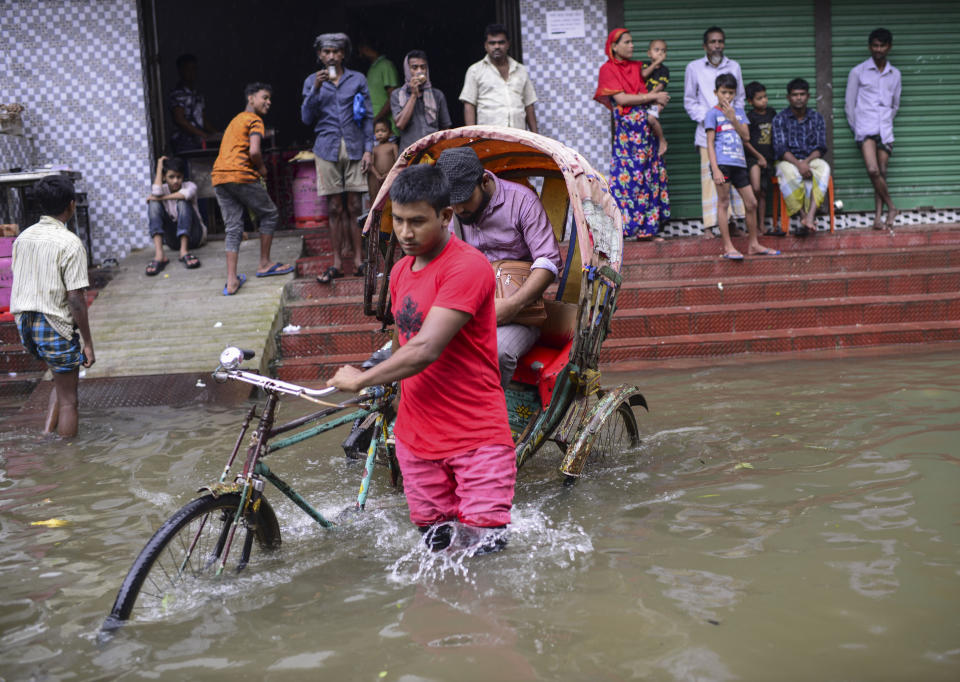 A rickshaw puller wades through flood waters in Sylhet, Bangladesh, Monday, June 20, 2022. Floods in Bangladesh continued to wreak havoc Monday with authorities struggling to ferry drinking water and dry food to flood shelters across the country’s vast northern and northeastern regions. (AP Photo/Mahmud Hossain Opu)