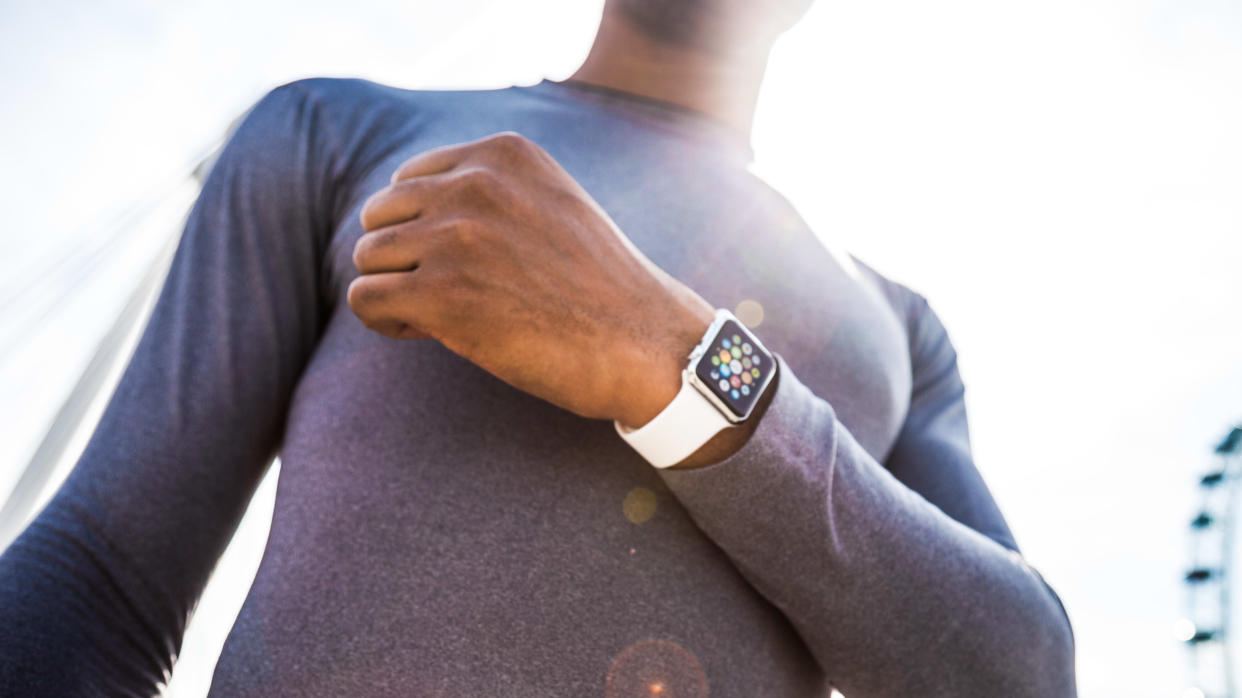 man wearing white smartwatch, apple watch against sky background