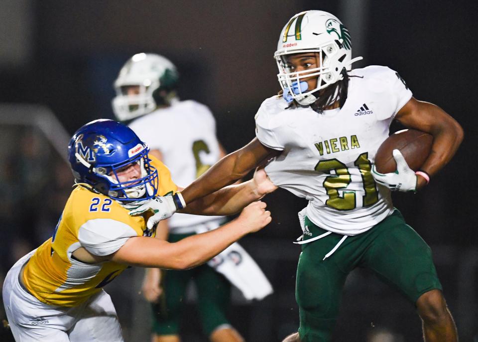 Viera's Cameron Mills (21) strong-arms Martin County's Mark White (22) in a Region 2-7A quarterfinal high school football playoff game on Friday, Nov. 12, 2021, in Stuart. Martin County won 26-15.