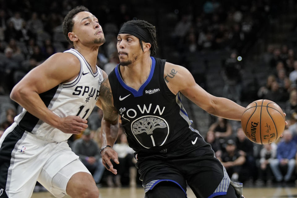 Golden State Warriors' Damion Lee (1) drives against San Antonio Spurs' Bryn Forbes during the first half of an NBA basketball game, Tuesday, Dec. 31, 2019, in San Antonio. (AP Photo/Darren Abate)