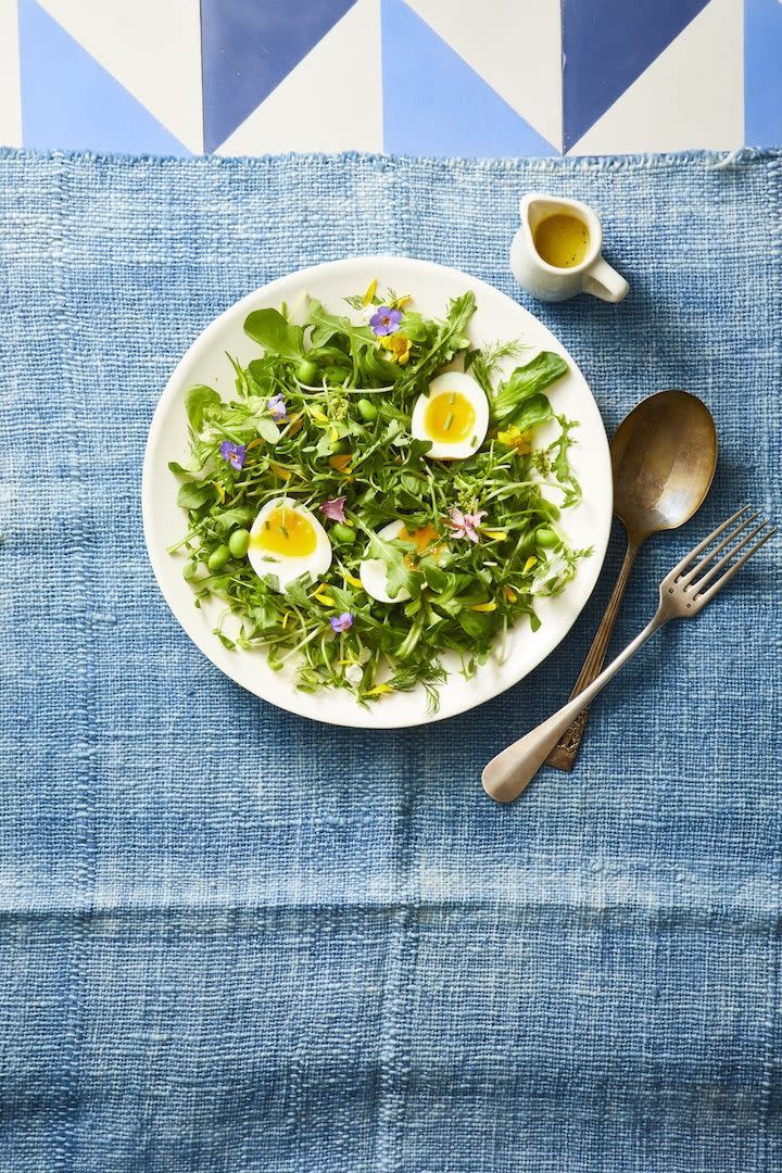 mixed green and herb toss salad topped with soft boiled eggs