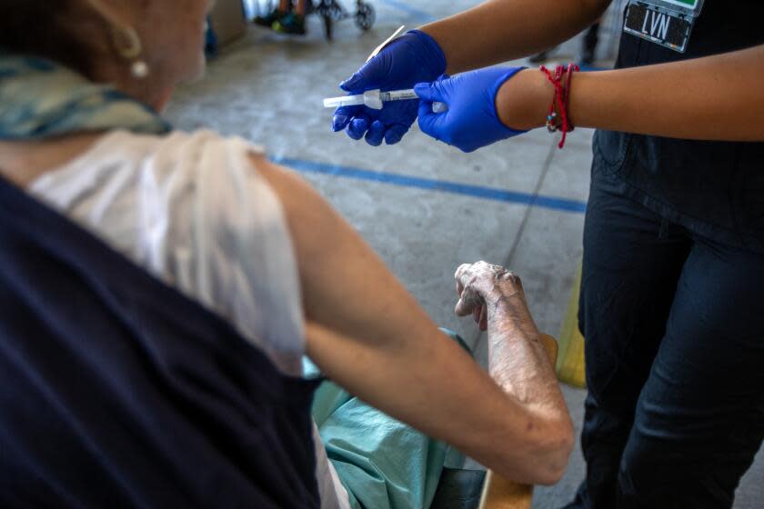 Pasadena, CA - October 12: Emily Cervantes, LVN, right, gives her patient a COVID-19 vaccine during a flu and COVID-19 vaccination clinic at Kaiser Permanente Pasadena on Thursday, Oct. 12, 2023, in Pasadena, CA. (Francine Orr / Los Angeles Times)