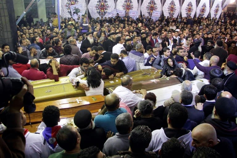 Egyptian Christians gather around and mourn by coffins during the late night funeral of the victims of a blast which killed worshippers attending Palm Sunday mass at the Mar Girgis Coptic Orthodox Church in the Nile Delta City of Tanta on April 9, 2017