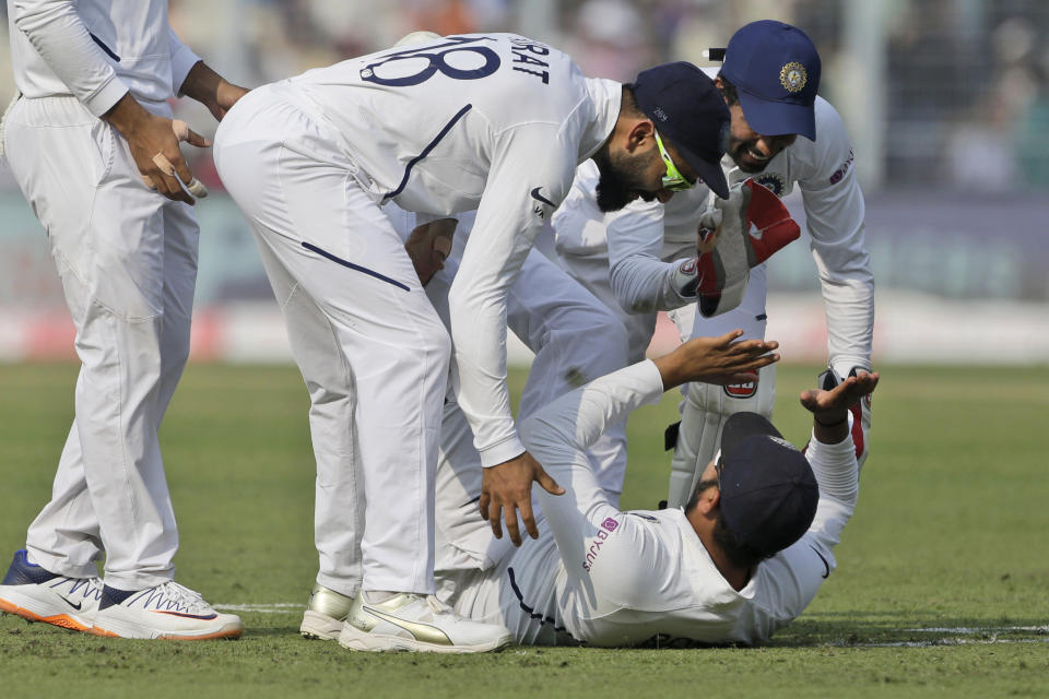 Indian cricket captain Virat Kohli, center, congratulates Rohit Sharma, on ground, for taking a catch to dismiss Bangladesh's Mominul Haque during the first day of the second test match between India and Bangladesh in Kolkata, India, Friday, Nov. 22, 2019. (AP Photo/Bikas Das)