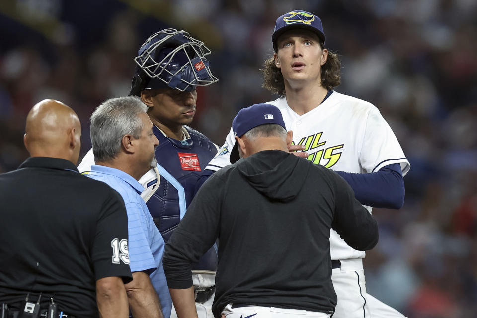 Tampa Bay Rays pitcher Tyler Glasnow, right, looks up as he is examined before being removed during the sixth inning of the team's baseball game against the Atlanta Braves on Friday, July 7, 2023, in St. Petersburg, Fla. (AP Photo/Mike Carlson)