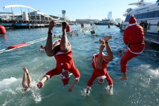 Nearly 300 people in bathing costumes or Santa suits dived into the frigid waters of Barcelona's port for a traditional Christmas Day swim