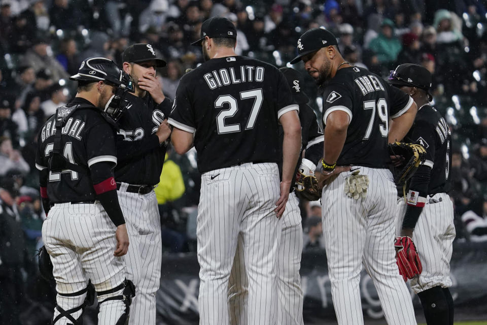 Chicago White Sox pitching coach Ethan Katz, second from left, talks with starting pitcher Lucas Giolito (27) during the sixth inning of a baseball game against the Los Angeles Angels in Chicago, Friday, April 29, 2022. (AP Photo/Nam Y. Huh)