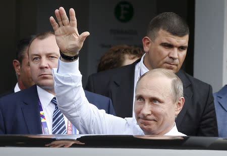 Russian President Vladimir Putin gestures as he leaves at the end of a joint news conference with Italian Prime Minister Matteo Renzi at the end of a meeting in Milan, northern Italy, June 10, 2015. REUTERS/Alessandro Garofalo