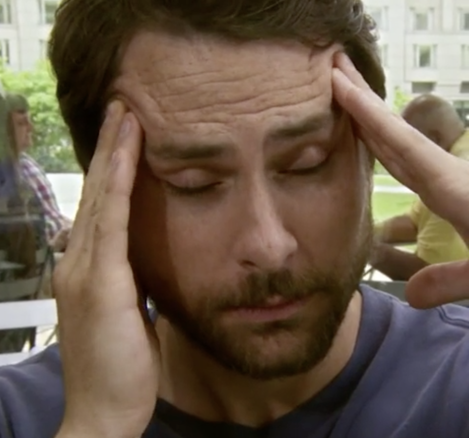 Charlie from It's Always Sunny in Philadelphia rubbing his temples from a headache