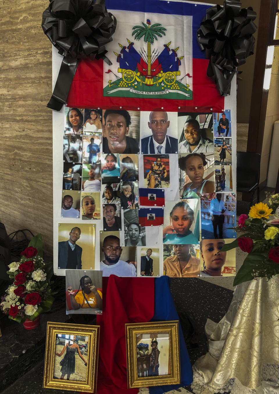 Ribbons and flags decorate the photos of the 11 Haitian women and others who went missing in last month when the overloaded boat they were in capsized, at a church in San Juan, Puerto Rico, Wednesday, June 15, 2022. The boat was carrying an estimated 60 to 75 migrants, of which eleven were found dead, at least a dozen still missing and 38 rescued. (AP Photo/Dánica Coto)